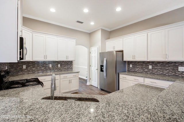 kitchen featuring visible vents, ornamental molding, light stone counters, a sink, and stainless steel appliances