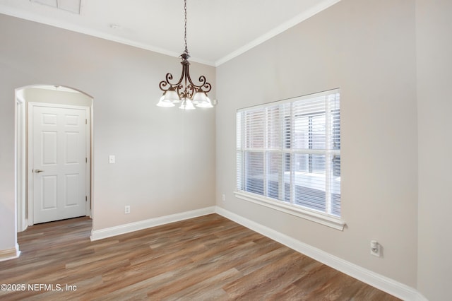 empty room with light wood-style flooring, arched walkways, an inviting chandelier, crown molding, and baseboards