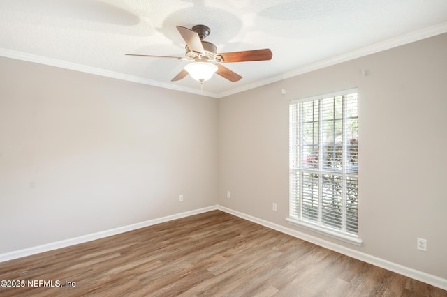 empty room featuring baseboards, wood finished floors, a ceiling fan, and ornamental molding