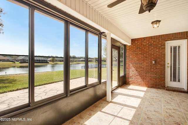 unfurnished sunroom with a water view and ceiling fan