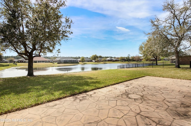 view of patio with a water view and fence