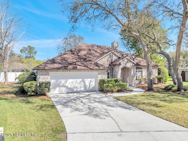 view of front of home featuring brick siding, a front yard, an attached garage, and driveway