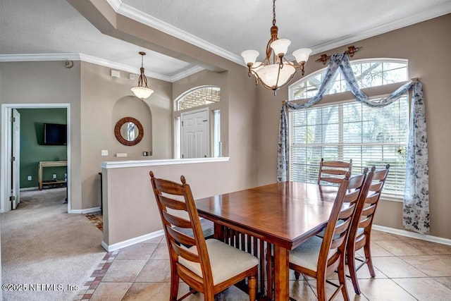 dining room featuring baseboards, a chandelier, light tile patterned flooring, and ornamental molding