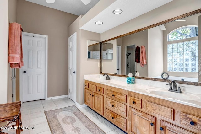 bathroom featuring tile patterned floors, double vanity, baseboards, and a sink