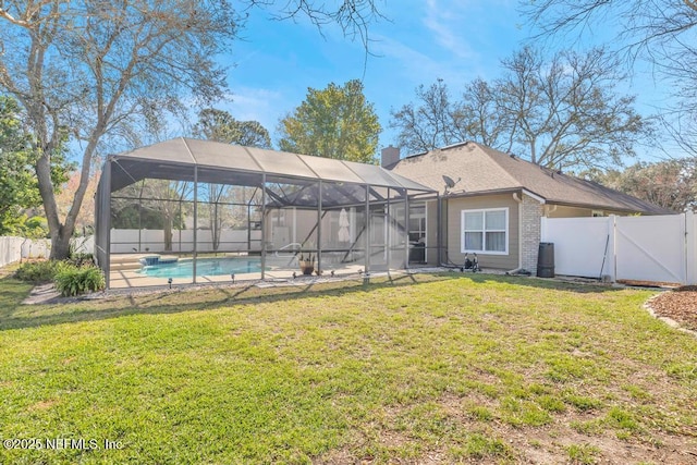 back of property with a yard, a fenced backyard, and a gate