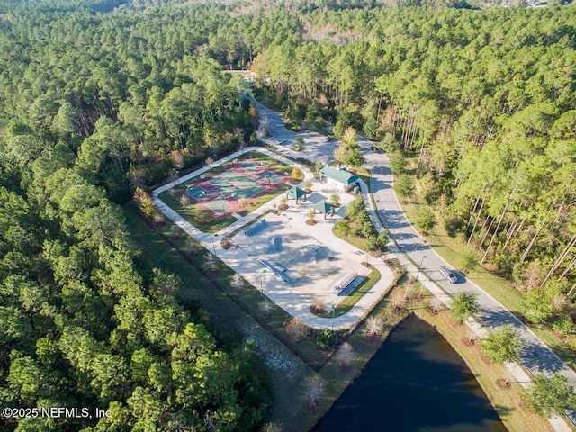 drone / aerial view featuring a view of trees and a water view