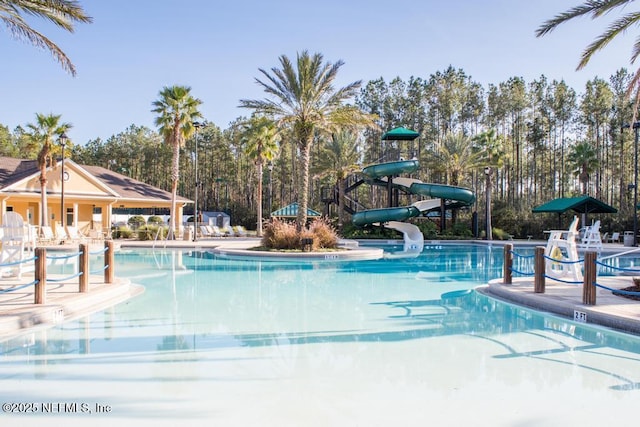 pool with a patio and a water slide