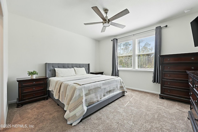 bedroom featuring light colored carpet, baseboards, and ceiling fan