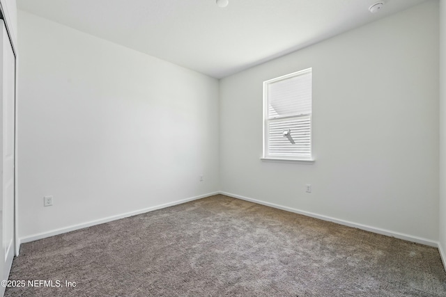 spare room featuring baseboards and carpet floors