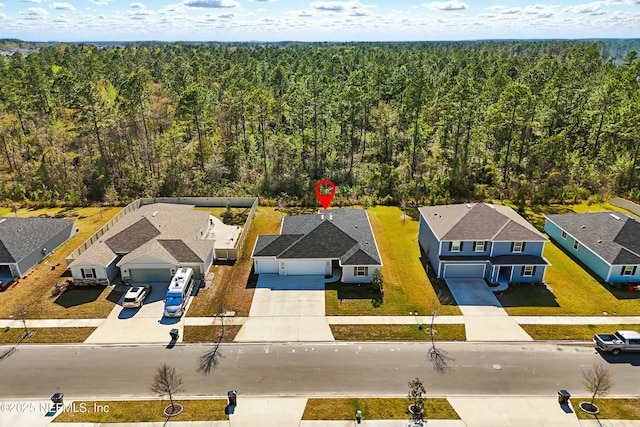 aerial view featuring a forest view and a residential view