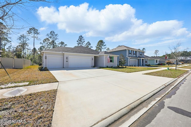 view of front of property with a garage, a front yard, driveway, and fence