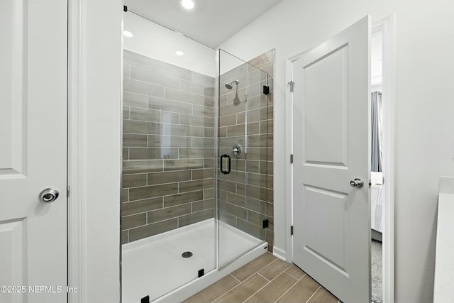 bathroom featuring recessed lighting, a stall shower, and wood finish floors