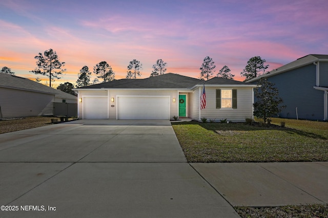 view of front of house with a lawn, driveway, and a garage