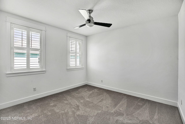 spare room featuring dark colored carpet, baseboards, a textured ceiling, and ceiling fan