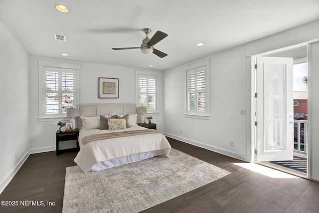 bedroom featuring visible vents, multiple windows, baseboards, and dark wood-style flooring