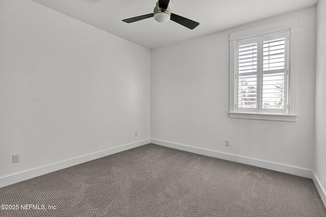 unfurnished room with dark carpet, baseboards, and ceiling fan