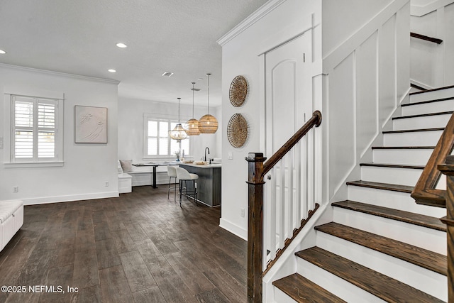 stairway featuring recessed lighting, baseboards, wood finished floors, and ornamental molding