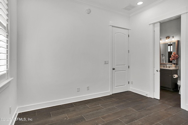 unfurnished room featuring wood finish floors, visible vents, baseboards, and ornamental molding