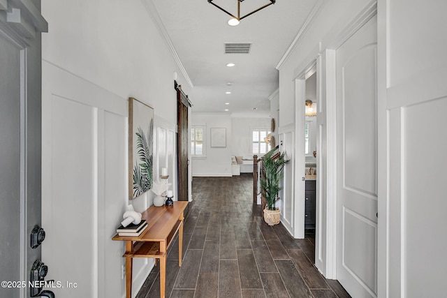 corridor featuring visible vents, recessed lighting, a barn door, crown molding, and wood tiled floor