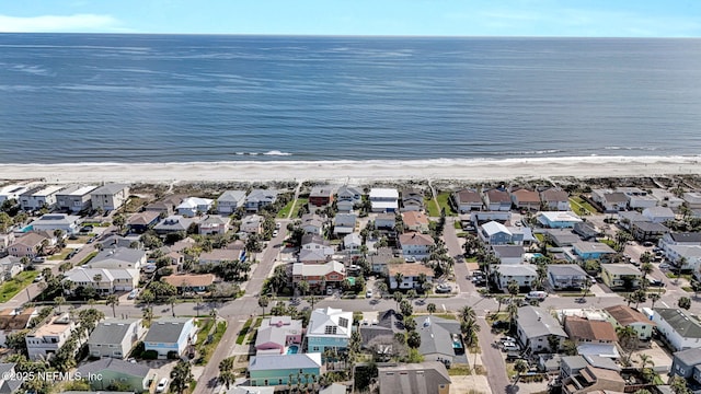 drone / aerial view featuring a view of the beach, a residential view, and a water view