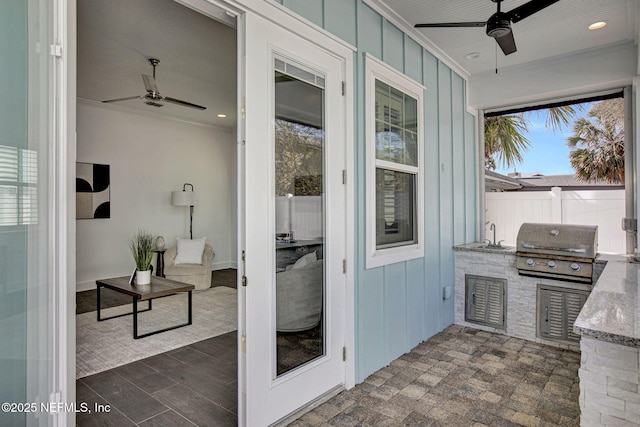 sunroom featuring a sink and a ceiling fan