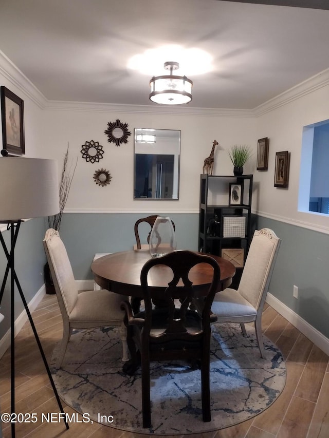 dining area featuring baseboards, wood finished floors, and crown molding