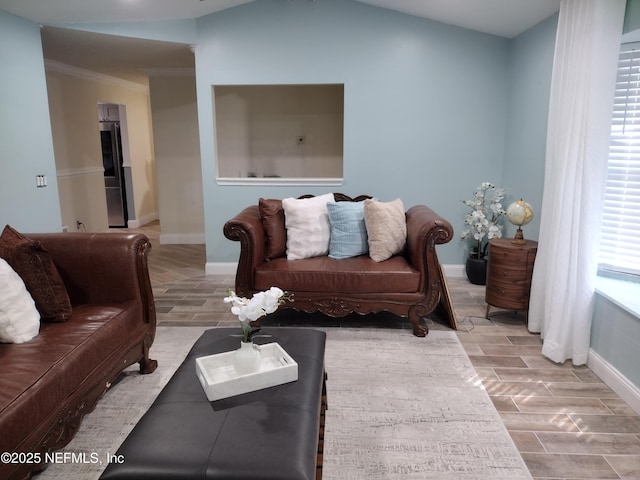 living area featuring baseboards, lofted ceiling, and wood finish floors