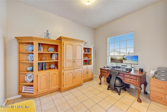 home office with baseboards, a textured ceiling, and light tile patterned flooring