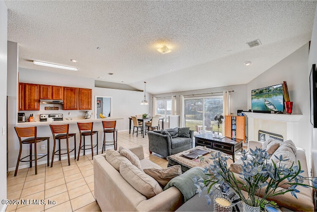 living room with lofted ceiling, light tile patterned floors, visible vents, and a textured ceiling