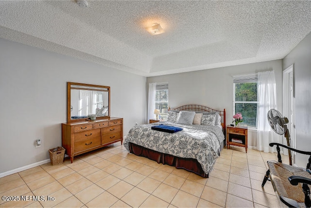 bedroom with light tile patterned floors, multiple windows, a textured ceiling, and baseboards