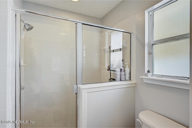 full bath featuring a shower stall and toilet