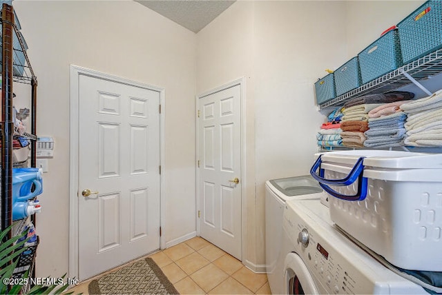 washroom featuring separate washer and dryer, light tile patterned flooring, and laundry area