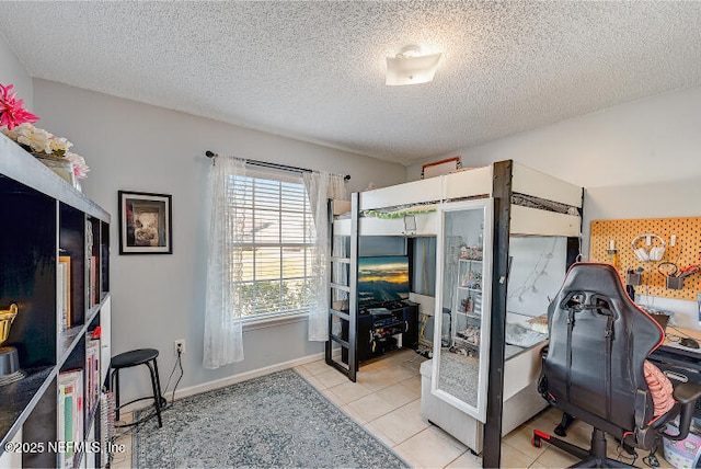 bedroom featuring light tile patterned flooring, baseboards, and a textured ceiling