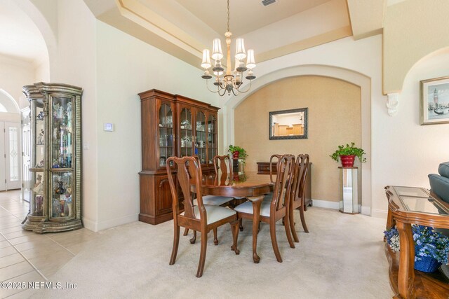 3 Village View Way, Palm Coast, FL 32137 - dining space with a tray ceiling, arched walkways, a notable chandelier, and light carpet