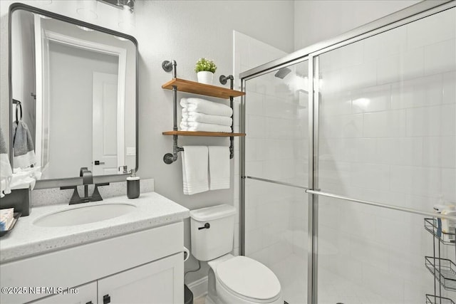 full bath featuring vanity, a shower stall, and toilet