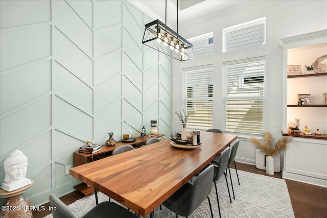 dining space with a decorative wall and wood finished floors