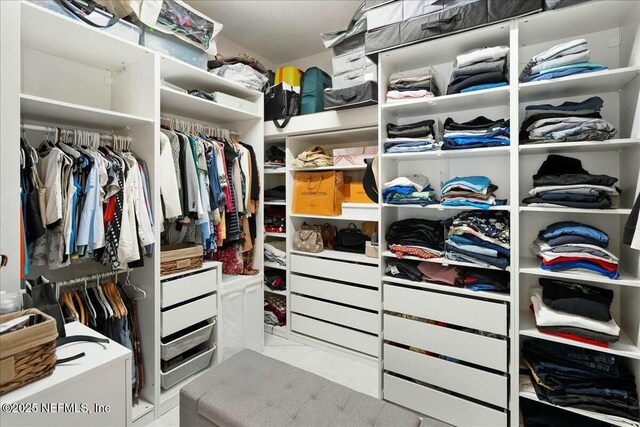 walk in closet with marble finish floor