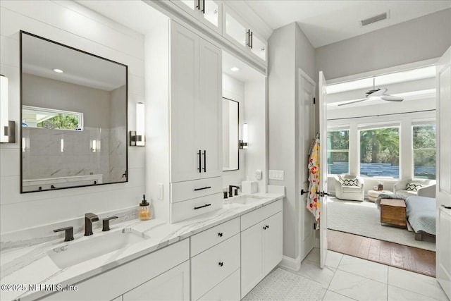 ensuite bathroom featuring visible vents, ensuite bath, ceiling fan, and a sink