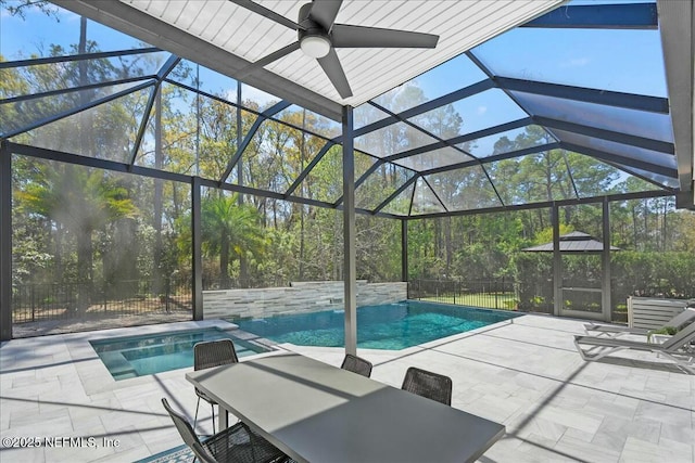 view of swimming pool featuring a patio area, glass enclosure, and fence