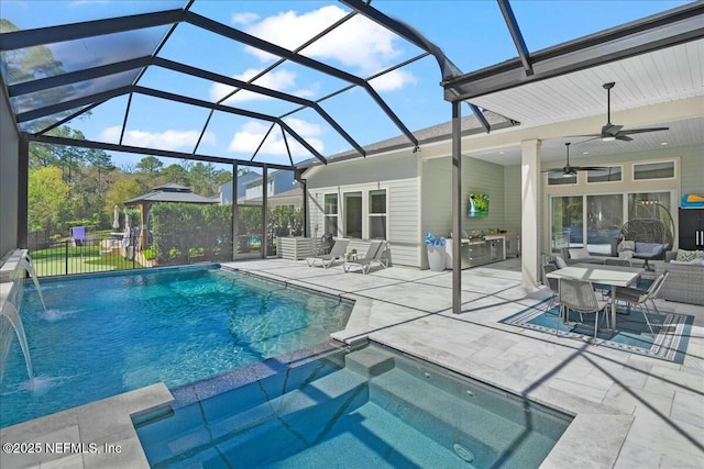 view of swimming pool featuring fence, a pool with connected hot tub, a lanai, and a patio area