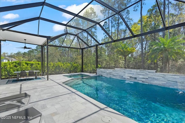 view of swimming pool with glass enclosure, a patio area, and a pool with connected hot tub