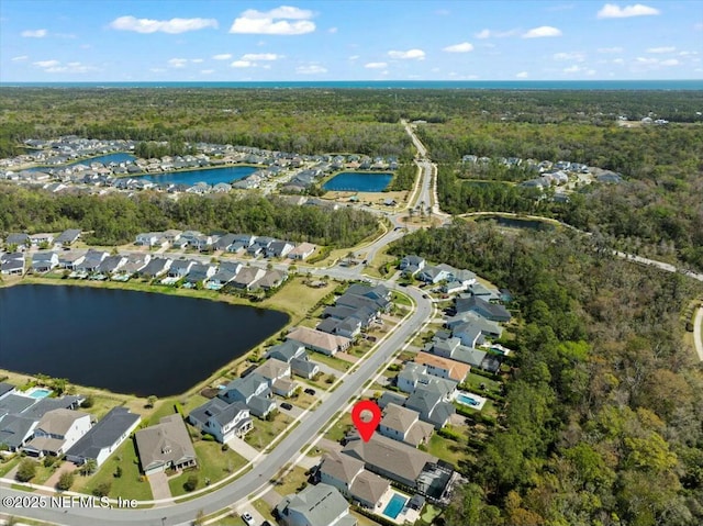 bird's eye view with a forest view, a water view, and a residential view