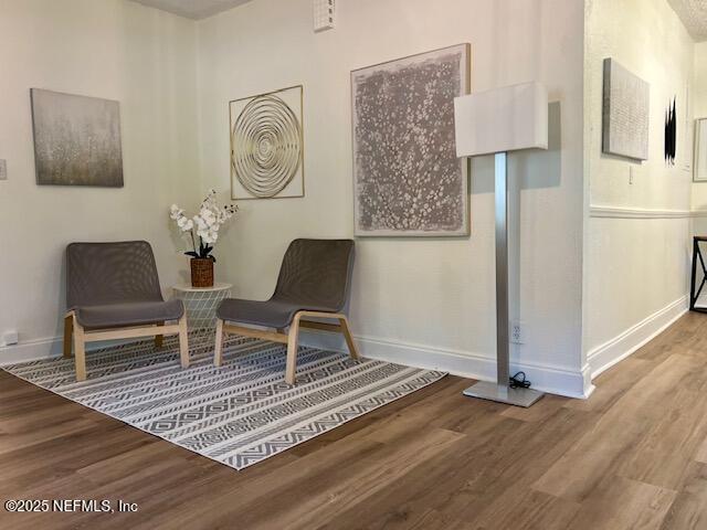 sitting room with wood finished floors and baseboards