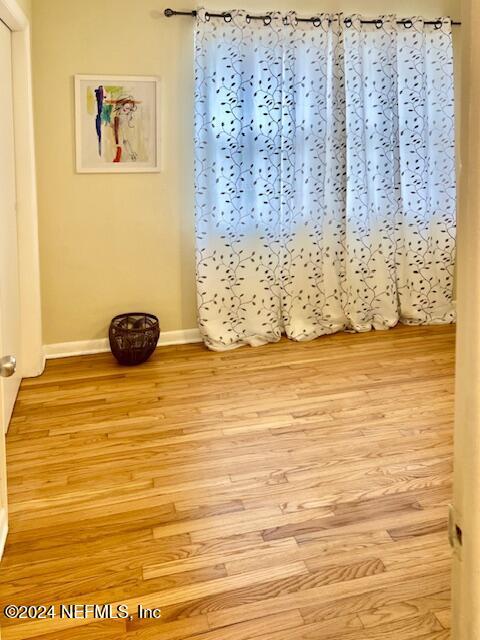 unfurnished room featuring baseboards and light wood finished floors