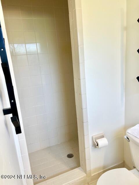 bathroom featuring toilet and a stall shower