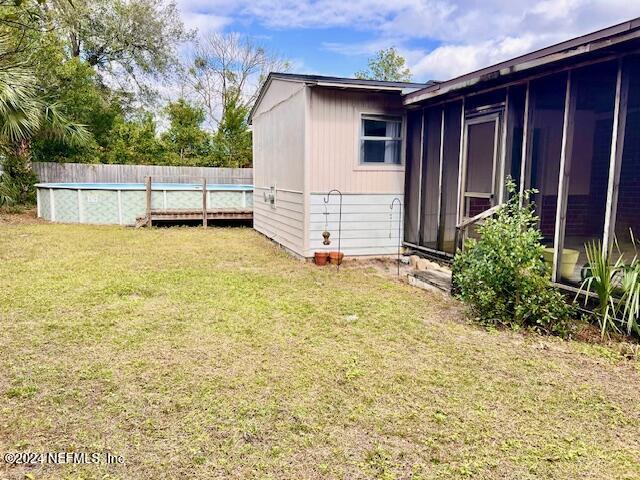 view of yard with a fenced in pool and a sunroom