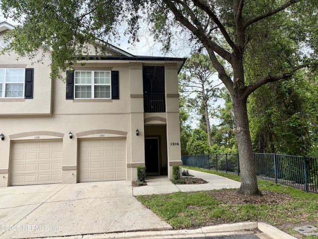 12301 Kernan Forest Blvd Unit 1206, Jacksonville, FL 32225 - view of front of property with stucco siding, an attached garage, driveway, and fence