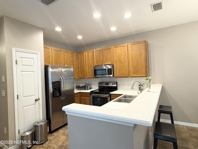 12301 Kernan Forest Blvd Unit 1206, Jacksonville, FL 32225 - kitchen with a sink, a breakfast bar, a peninsula, appliances with stainless steel finishes, and visible vents