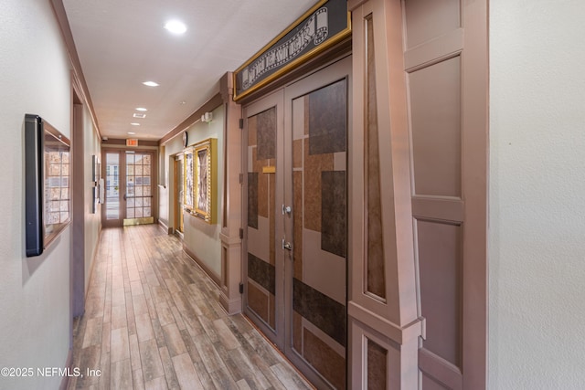 hall with recessed lighting, french doors, baseboards, and light wood finished floors