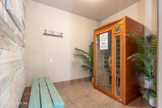 interior space with a sauna, baseboards, and tile patterned flooring